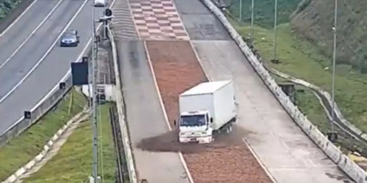Motorista chegou a entrar pela pista lateral, mas logo jogou o caminhão dentro da caixa de britas. (Foto: Reprodução / Arteris Litoral Sul)