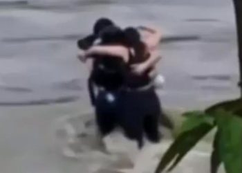 Amigos se abraçam momentos antes de serem arrastados por enchente